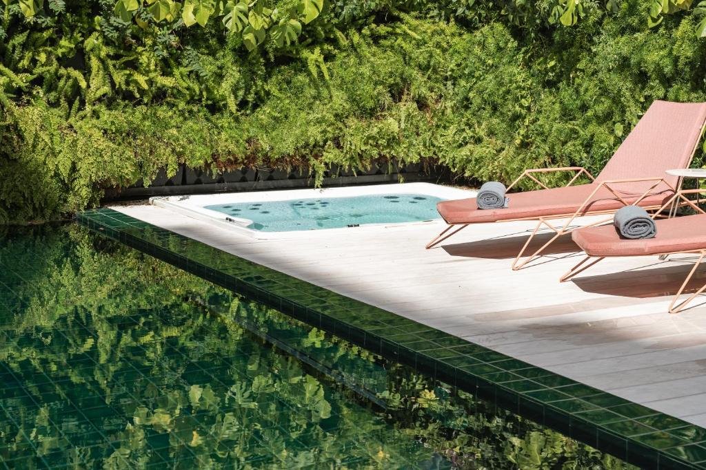 Luxury poolside scene with sun loungers, rolled towels, and lush greenery. Perfect for relaxation and leisure.