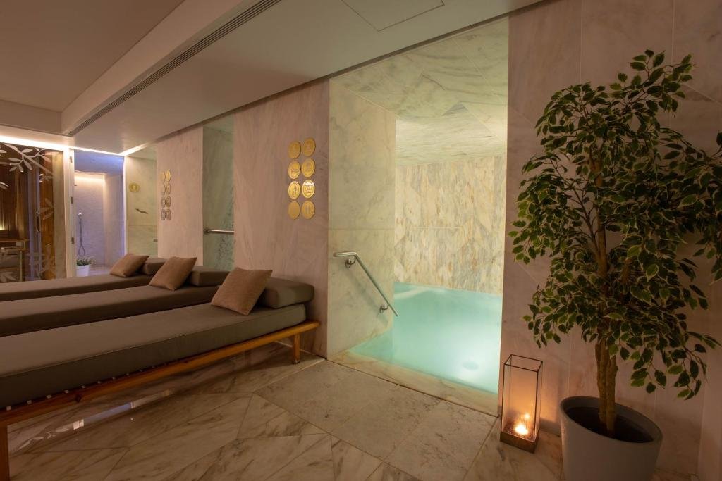 Luxurious spa room with loungers, softly lit pool, and relaxing decor for ultimate tranquility.