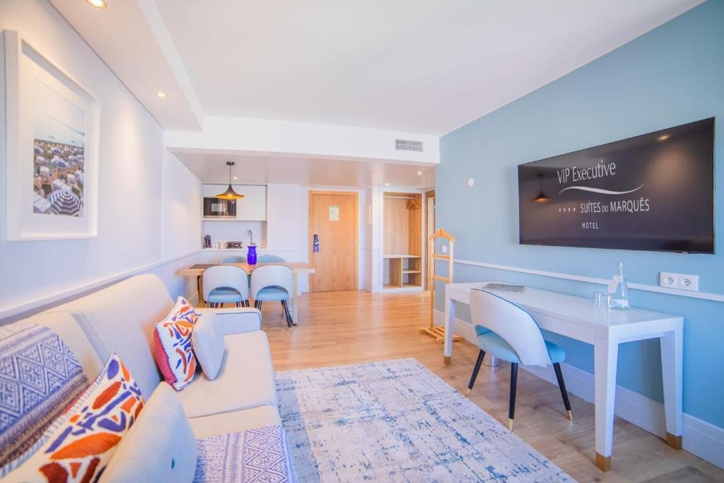 Bright hotel suite with modern decor, featuring a cozy living area and a sleek desk space.