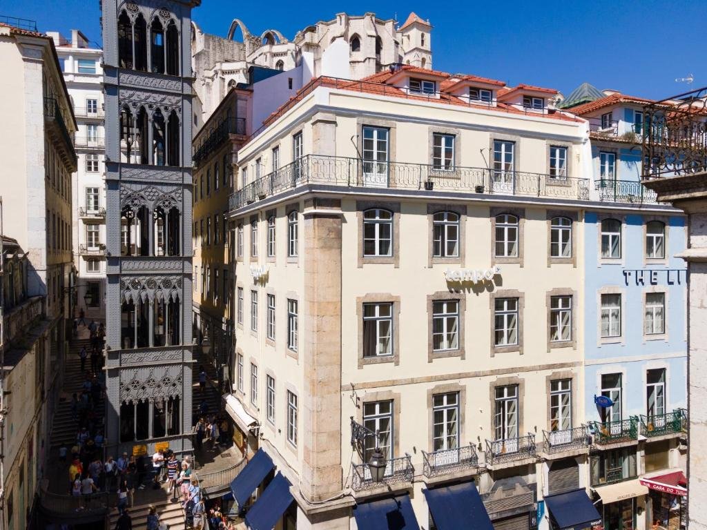 Historic metal lift and European architecture under a clear blue sky in Lisbon city center.