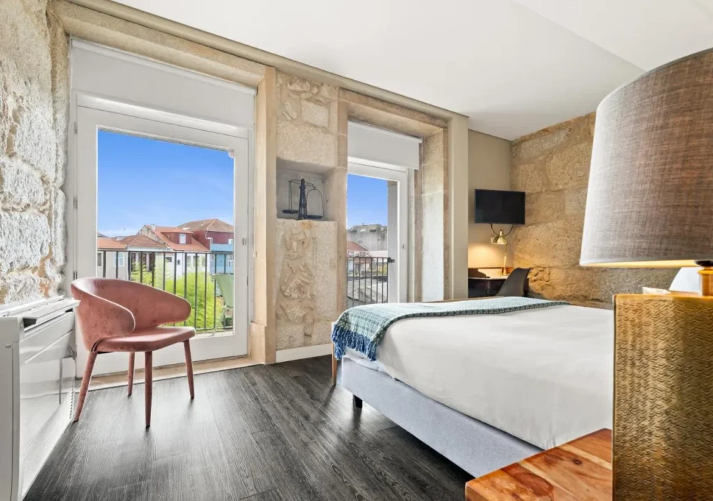 Modern hotel room with large windows, stylish decor, and a scenic view. Ideal for a relaxing stay.