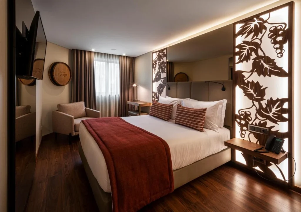 Elegant hotel room with modern decor, cozy bed, wooden accents, and warm lighting. Perfect for a comfortable stay.